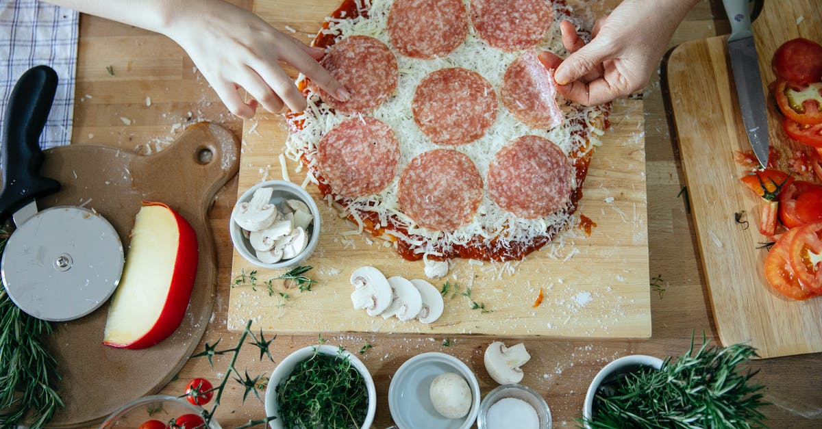 Can I put frozen meat in a slow cooker? - Top view of crop unrecognizable people adding salami in homemade pizza placed on wooden table among various fresh ingredients while cooking together Can I put frozen meat in a slow cooker? - Top view of crop unrecognizable people adding salami in homemade pizza placed on wooden table among various fresh ingredients while cooking together