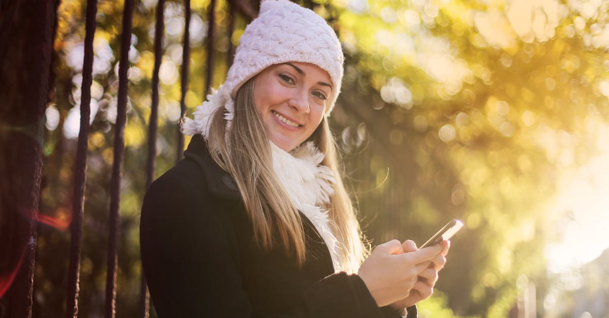 Can I season cast iron *without* using an oven? - Smiling woman chatting on smartphone in park Can I season cast iron *without* using an oven? - Smiling woman chatting on smartphone in park