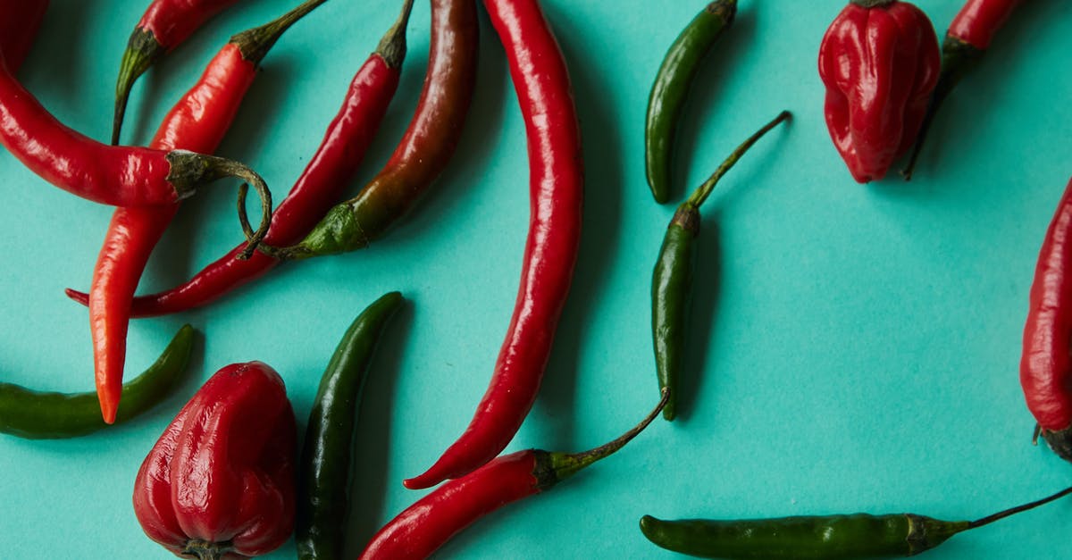 Can I use a whole uncut green pepper that I accidentally froze or is it garbage? - Top view of various types of fresh ripe colorful chili peppers scattered on light blue background Can I use a whole uncut green pepper that I accidentally froze or is it garbage? - Top view of various types of fresh ripe colorful chili peppers scattered on light blue background