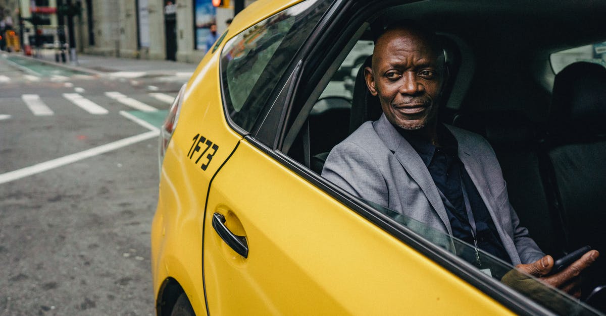 Can I Use Yellow Split Peas in Paruppu Urundai instead of Toor Dal - Happy confident mature African American male looking away and expecting important message on mobile phone while sitting in yellow automobile