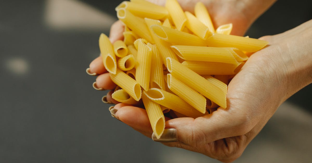 Can Lasagna be frozen before cooking, if using uncooked lasagna noodles, not the no boil type - Unrecognizable female demonstrating heap of uncooked penne rigate pasta with ridged surface in hands while standing in kitchen with sunlight Can Lasagna be frozen before cooking, if using uncooked lasagna noodles, not the no boil type - Unrecognizable female demonstrating heap of uncooked penne rigate pasta with ridged surface in hands while standing in kitchen with sunlight