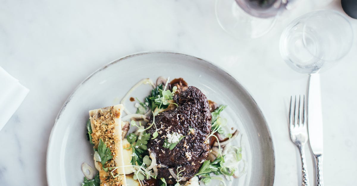 Can meat freeze from the inside out? - Top view of delicious stuffed celery and grilled steal decorated with green herbs served on table with cutlery and glassware