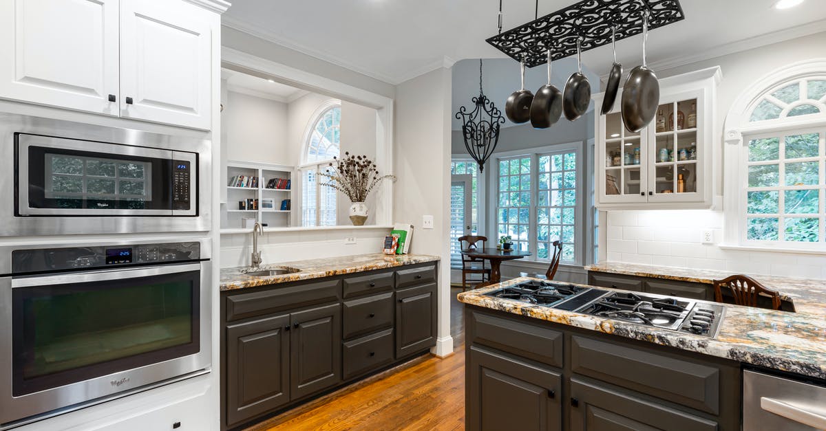 Can nonstick pans go in the oven? - Pots and Pans Hanging Over a Stove on a Kitchen Counter Can nonstick pans go in the oven? - Pots and Pans Hanging Over a Stove on a Kitchen Counter