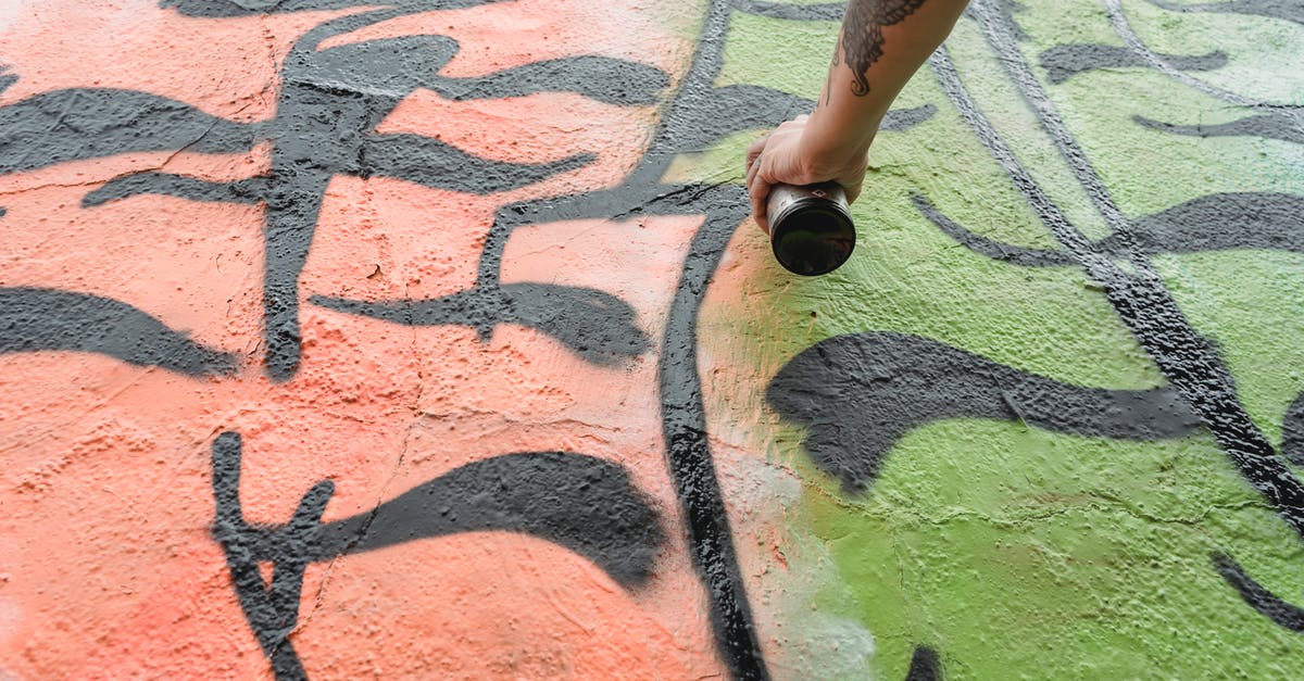 Can one tell from the outside whether a papaya has seeds? - From below of crop anonymous talented painter with tattoo spraying paint on wall with colorful patterns on street in city Can one tell from the outside whether a papaya has seeds? - From below of crop anonymous talented painter with tattoo spraying paint on wall with colorful patterns on street in city