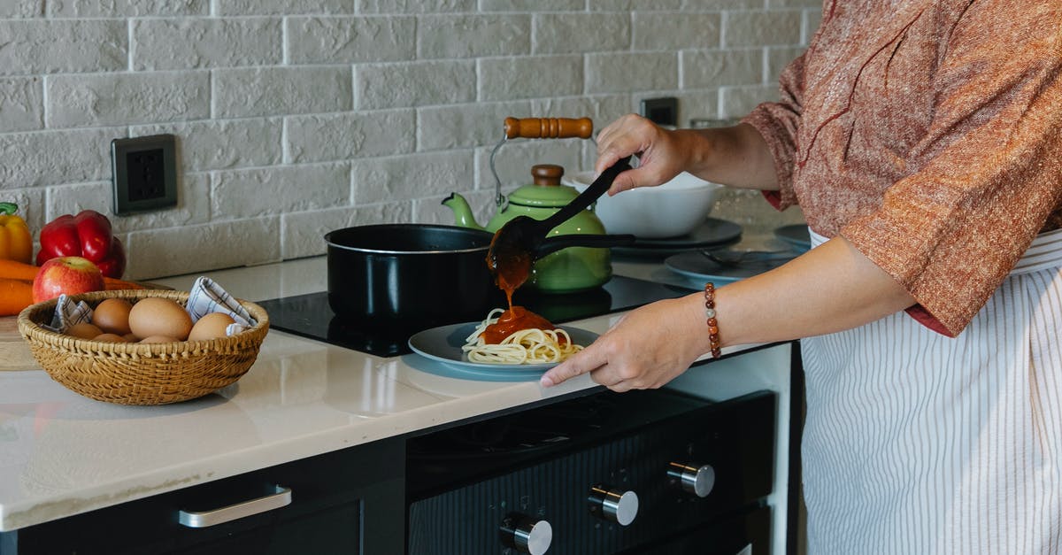 Can you add seasoning halfway through cooking with sous vide - Side view crop housewife in apron cooking lunch in kitchen and adding fresh delicious tomato sauce to Italian pasta Can you add seasoning halfway through cooking with sous vide - Side view crop housewife in apron cooking lunch in kitchen and adding fresh delicious tomato sauce to Italian pasta