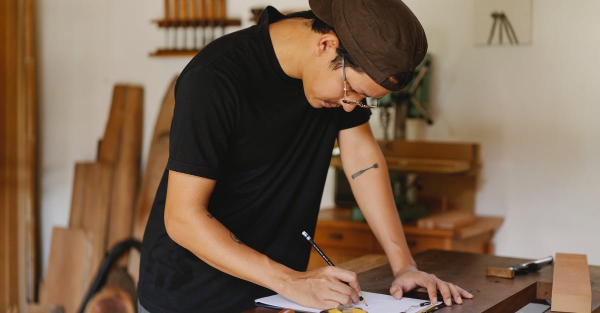Can you estimate how long it takes to reduce a liquid? - Side view of Asian man in casual clothes and eyeglasses bending on table and taking notes by pencil while working in joinery Can you estimate how long it takes to reduce a liquid? - Side view of Asian man in casual clothes and eyeglasses bending on table and taking notes by pencil while working in joinery