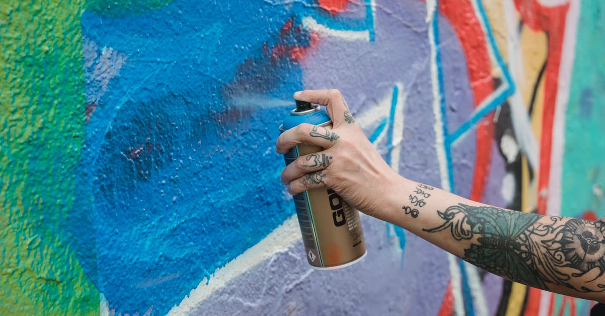 Can you identify this Serbian street food? - Crop unrecognizable tattooed painter spraying blue paint from can on multicolored wall with creative graffiti while standing on street in city Can you identify this Serbian street food? - Crop unrecognizable tattooed painter spraying blue paint from can on multicolored wall with creative graffiti while standing on street in city