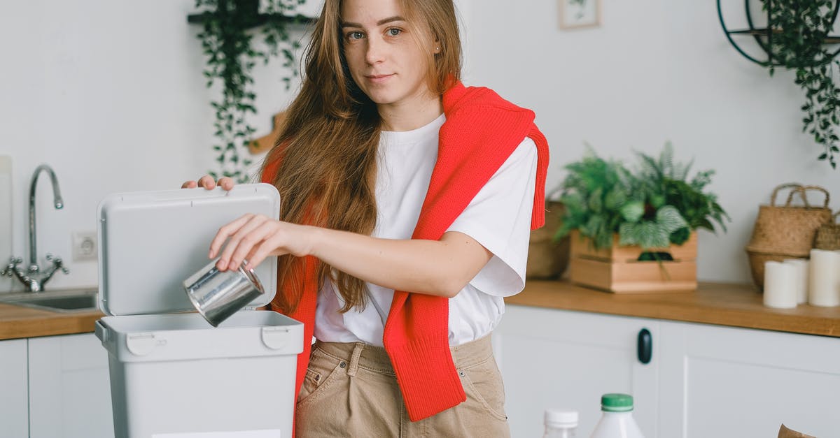 Can you preserve zest? - Responsible female sorting garbage while putting tin can into container for metal litter and looking at camera Can you preserve zest? - Responsible female sorting garbage while putting tin can into container for metal litter and looking at camera