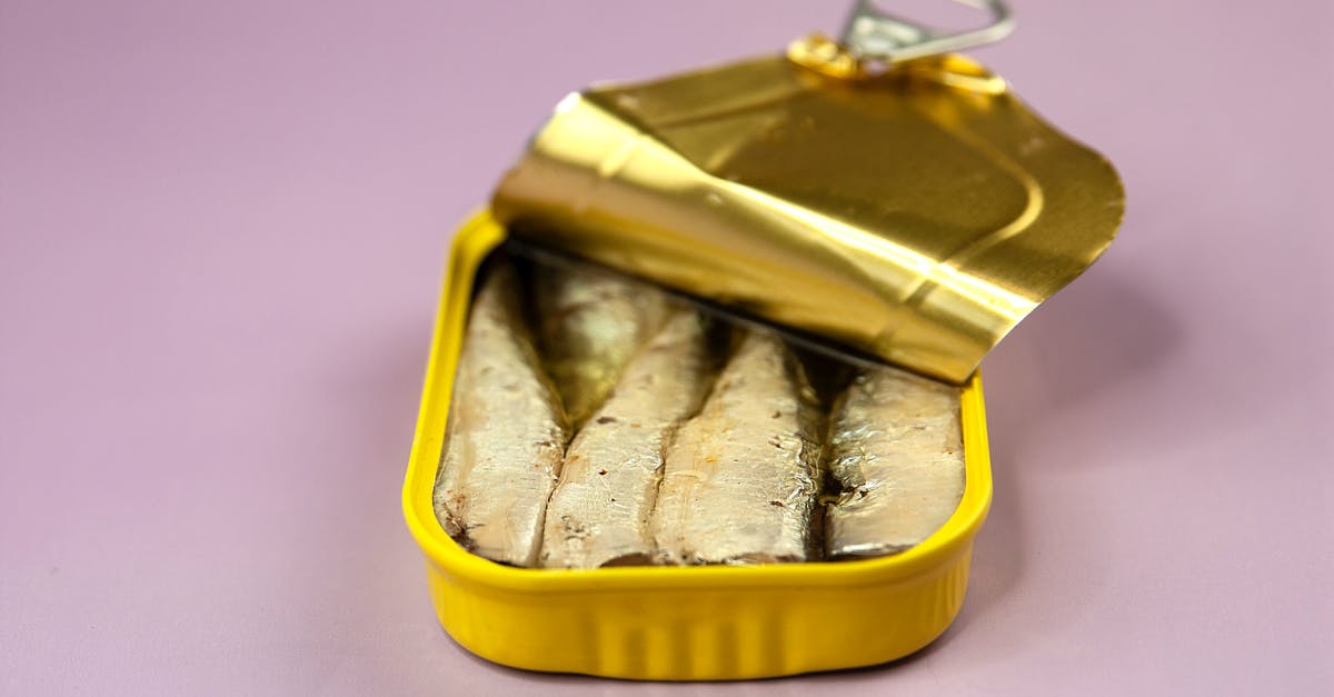 Canned yams vs. fresh - Canned fish in package on lilac background Canned yams vs. fresh - Canned fish in package on lilac background