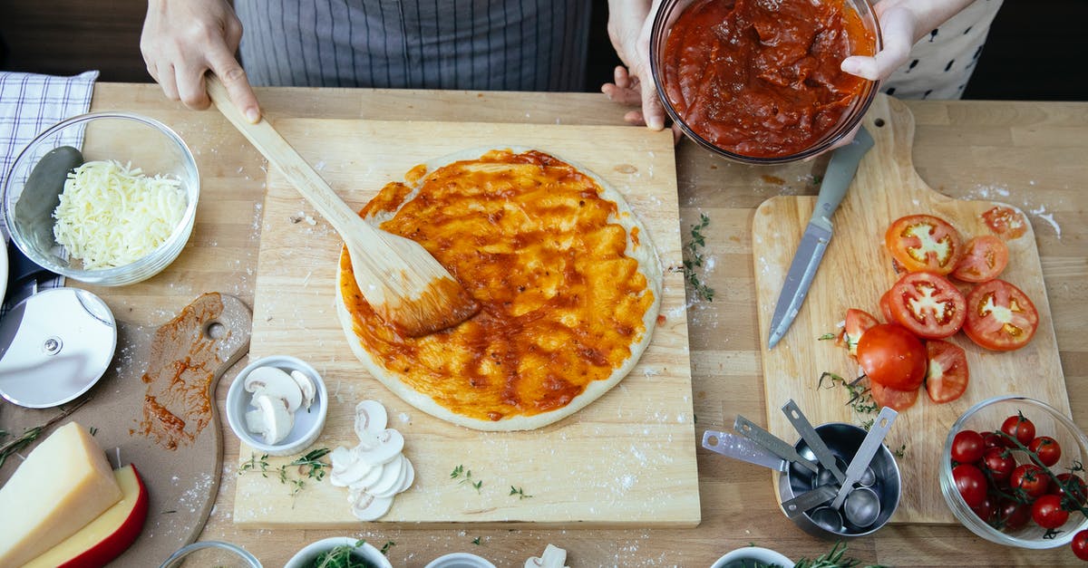 Canning cheese spreads? - Crop women spreading tomato sauce on pizza Canning cheese spreads? - Crop women spreading tomato sauce on pizza