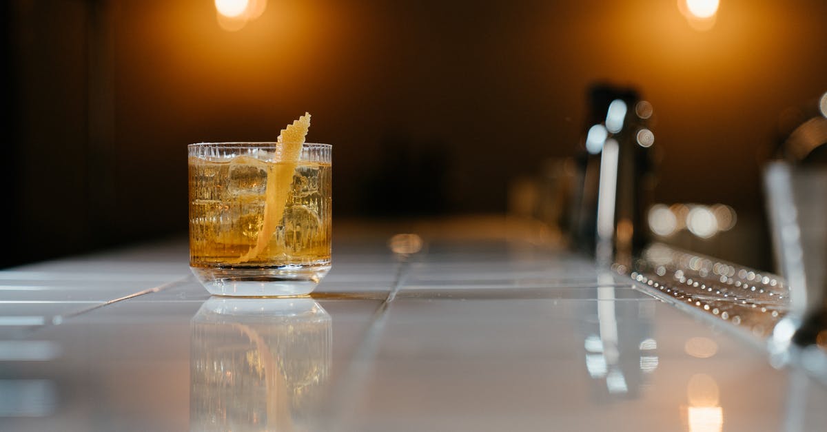 Caramel Apple cocktail garnish - Clear Drinking Glass With Yellow Liquid on Table Caramel Apple cocktail garnish - Clear Drinking Glass With Yellow Liquid on Table