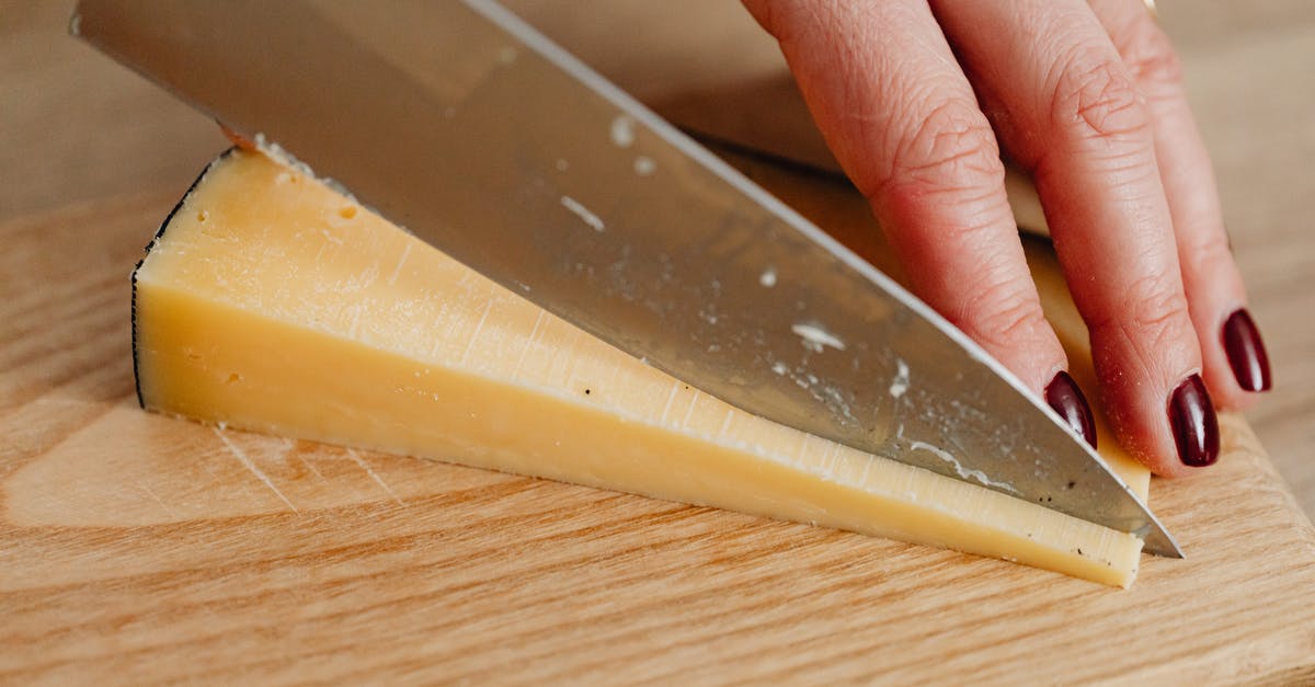 Cheese Cutting Tools - Person Holding Stainless Steel Kitchen Knife Slicing a Cheese Cheese Cutting Tools - Person Holding Stainless Steel Kitchen Knife Slicing a Cheese
