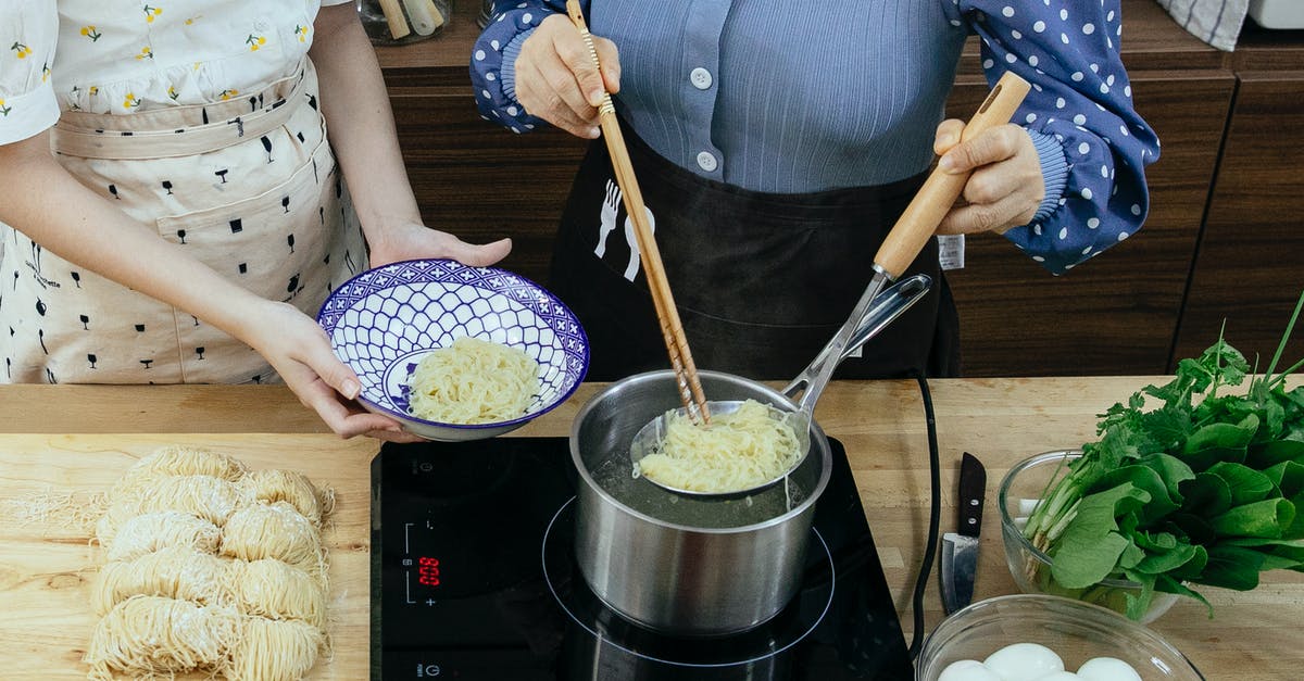 Cheese that Pairs with Spicy Food - Women cooking noodles in kitchen Cheese that Pairs with Spicy Food - Women cooking noodles in kitchen