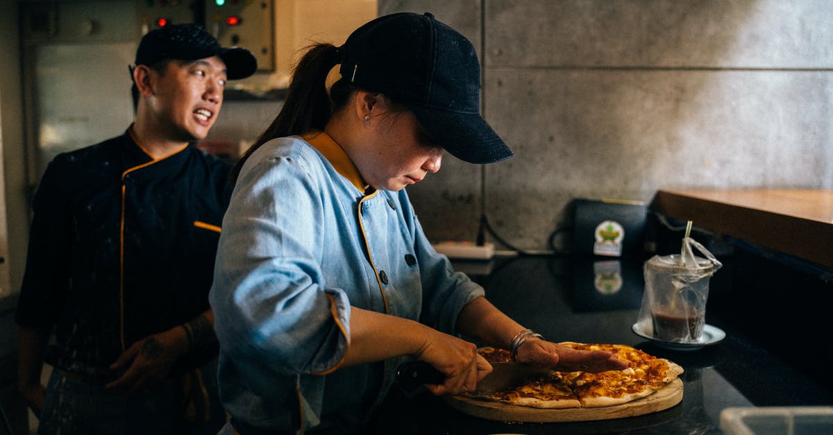 chef's knife for cutting chicken, or butcher's - A Woman Cutting a Pizza with a Knife chef's knife for cutting chicken, or butcher's - A Woman Cutting a Pizza with a Knife