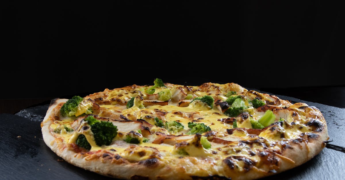 Chicken fat solidifies on hot broth - Single chicken pizza on a black background Chicken fat solidifies on hot broth - Single chicken pizza on a black background