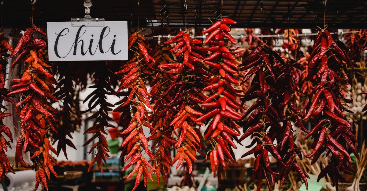 Chili pepper size vs heat - Red Chili on Brown Wooden Table Chili pepper size vs heat - Red Chili on Brown Wooden Table