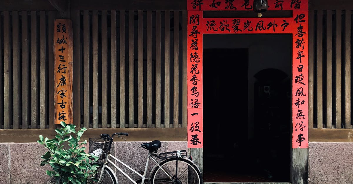Chinese Hoppin' John - Black City Bike Parked Beside Red Wooden Door Chinese Hoppin' John - Black City Bike Parked Beside Red Wooden Door