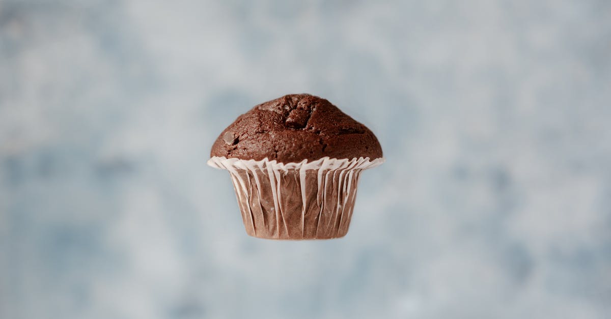 Chocolate chip substitutions - Sweet chocolate muffin hanging in air on blurred background Chocolate chip substitutions - Sweet chocolate muffin hanging in air on blurred background