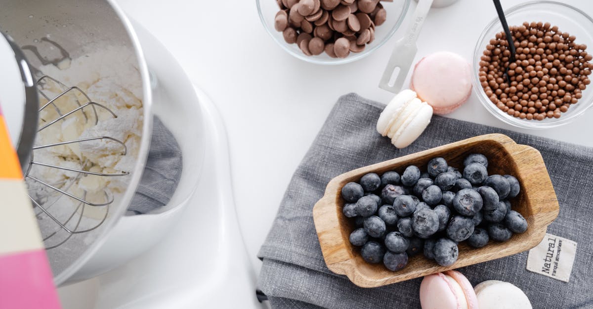 Chocolate for topping didn't melt - From above composition planetary mixer macaroons wooden bowl with blueberry and chocolate disks for melting Chocolate for topping didn't melt - From above composition planetary mixer macaroons wooden bowl with blueberry and chocolate disks for melting
