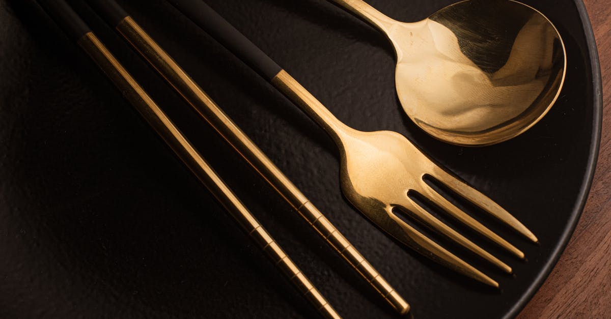 Chopsticks versus forks? - Silverwares on a Black Ceramic Plate Chopsticks versus forks? - Silverwares on a Black Ceramic Plate