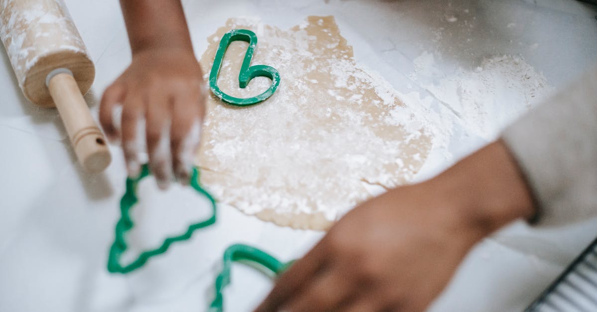 Choux pastry, general questions with gluten free flour - From above of crop anonymous black kid and parent using decorative pastry cutters on table with dough Choux pastry, general questions with gluten free flour - From above of crop anonymous black kid and parent using decorative pastry cutters on table with dough