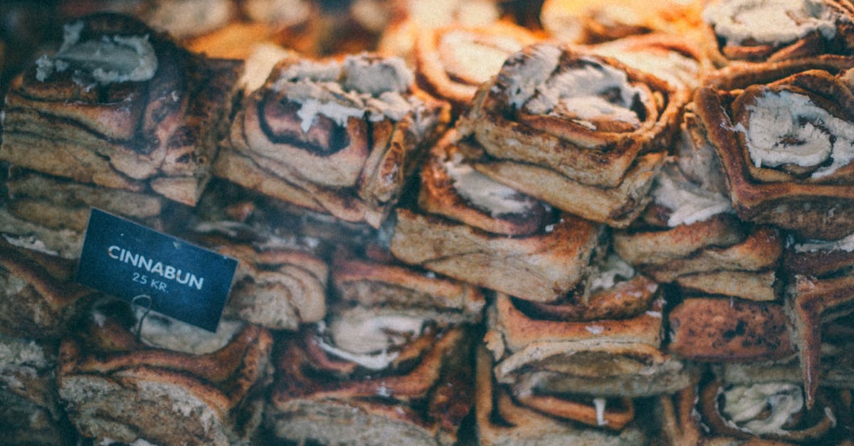 Cinnamon Roll Filling - Through glass of sweet delicious buns with sugar powder and cream placed on counter in shop