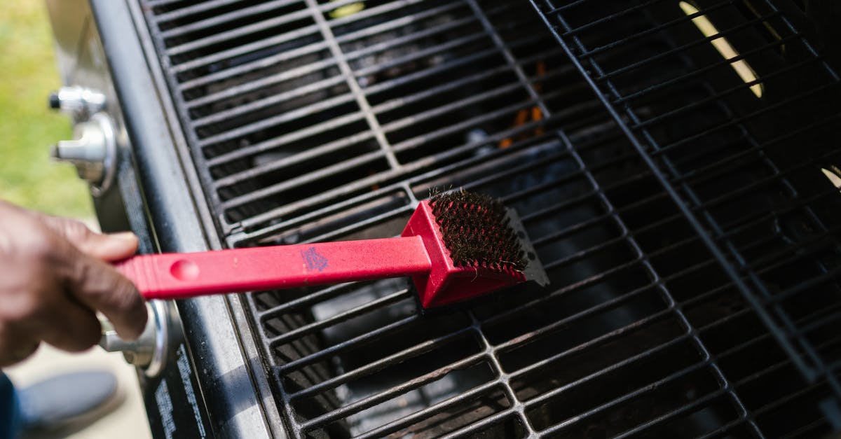 Cleaning 'cement' from grill - Person Brushing the Griller Cleaning 'cement' from grill - Person Brushing the Griller