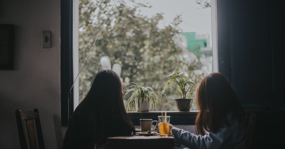 Cleaning out coffee pots and thermoses - Two Women Sitting at Table Near Window Cleaning out coffee pots and thermoses - Two Women Sitting at Table Near Window