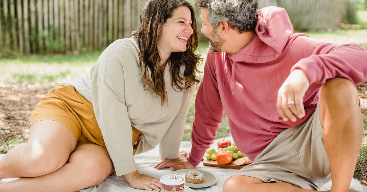 Closest thing to a donut I can drink coffee out of - Happy couple enjoying picnic together Closest thing to a donut I can drink coffee out of - Happy couple enjoying picnic together