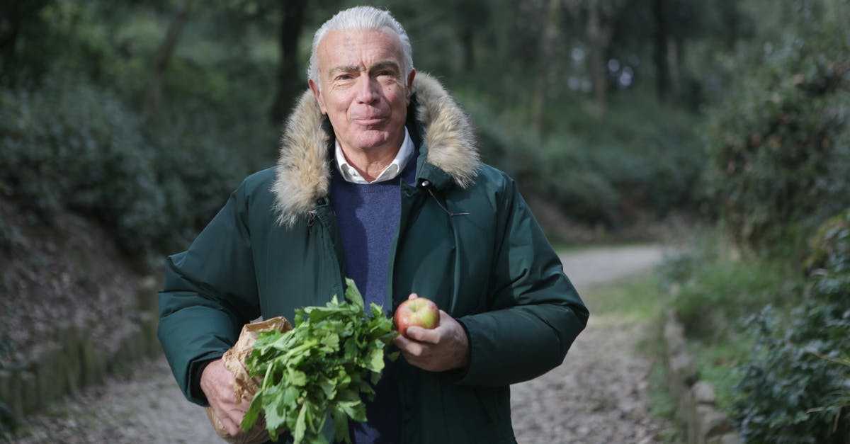 Coating fruit in Oreos - Man in Green Fur Coat Holding Vegetable and Apple Fruit Coating fruit in Oreos - Man in Green Fur Coat Holding Vegetable and Apple Fruit