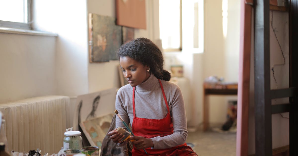 Colouring oil - chocolate look alike - Young woman working in creative workshop Colouring oil - chocolate look alike - Young woman working in creative workshop