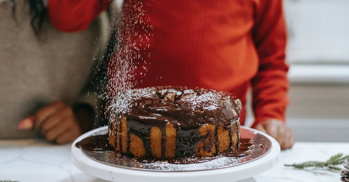 Commercial Sponge Cake Improver? - Crop black mother with kid decorating cake with powdered sugar