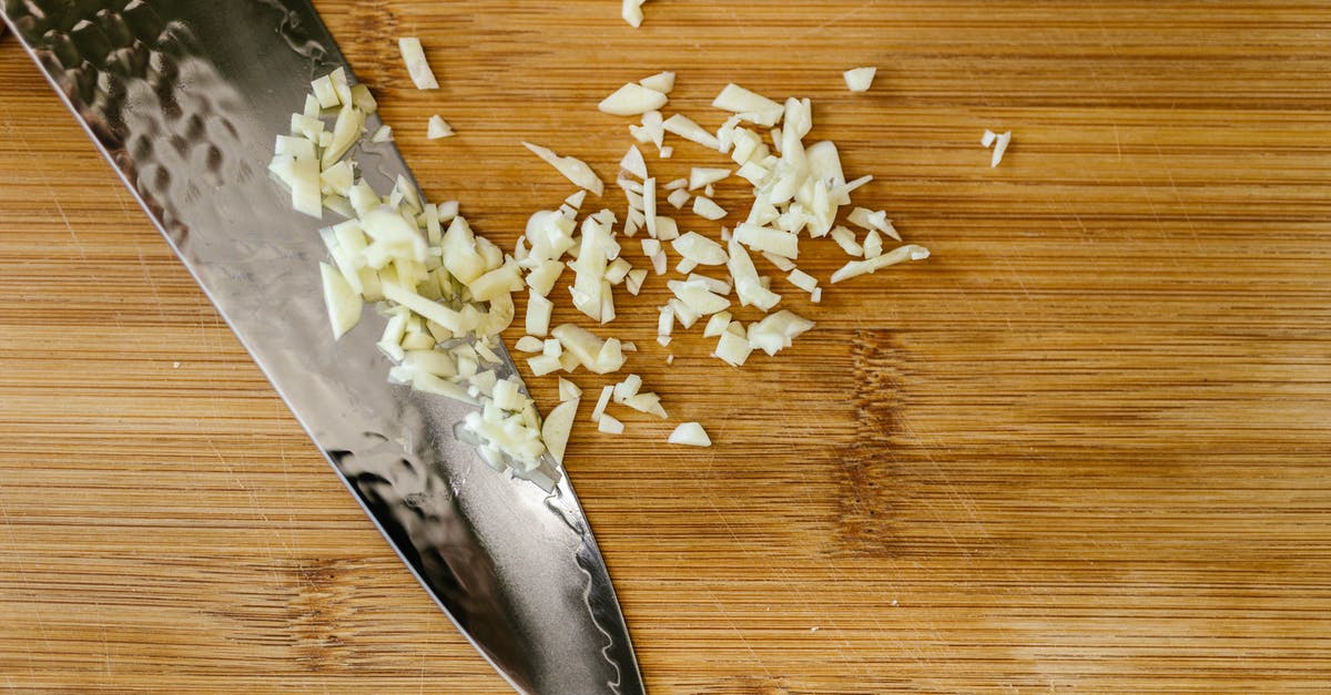 Comparing store-bought chopped garlic - Knife with Chopped Garlic on Cutting Board Comparing store-bought chopped garlic - Knife with Chopped Garlic on Cutting Board