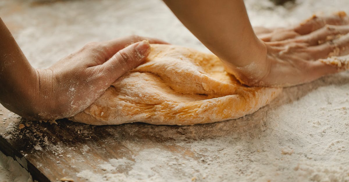 Converting bread recipes for an overnight rise? - Unrecognizable female kneading soft fresh egg dough on cutting board with flour in kitchen