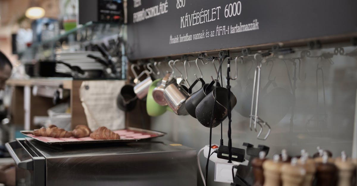 Cook steak in oven with tray meant for deserts? - Various metal cups hanging on hooks near wall above oven with tray with freshly backed croissants in kitchen of modern cafe Cook steak in oven with tray meant for deserts? - Various metal cups hanging on hooks near wall above oven with tray with freshly backed croissants in kitchen of modern cafe