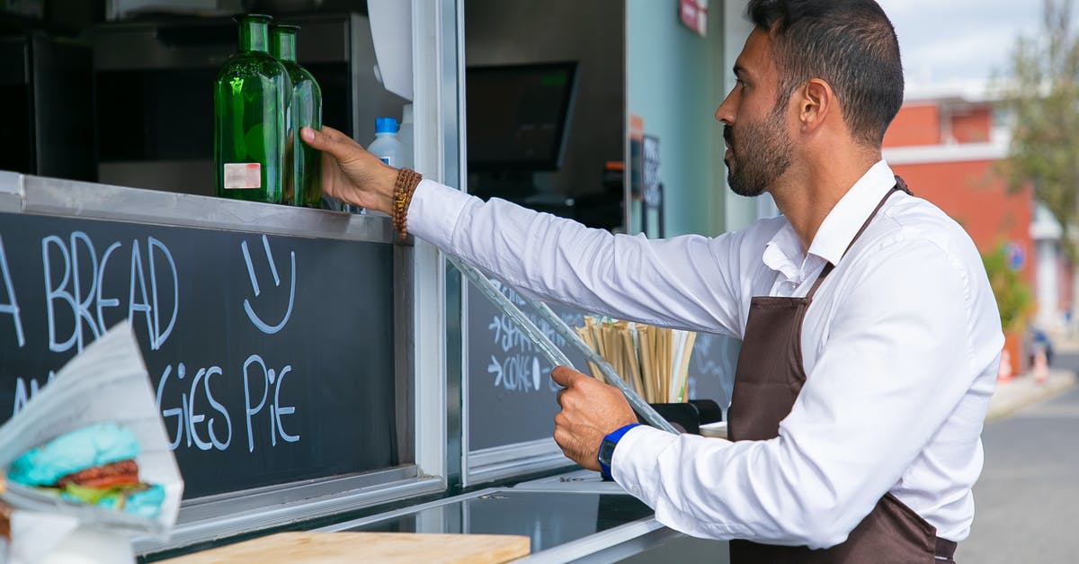 Cook Time vs. Cook Temp trade off - Focused ethnic male worker placing glass bottle at counter Cook Time vs. Cook Temp trade off - Focused ethnic male worker placing glass bottle at counter
