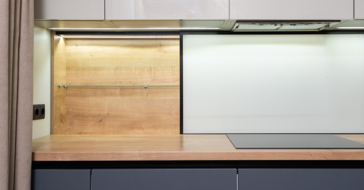 Cook with no hood - how to control smell - Cook top built in wooden table under cupboard with hood in modern light house kitchen Cook with no hood - how to control smell - Cook top built in wooden table under cupboard with hood in modern light house kitchen