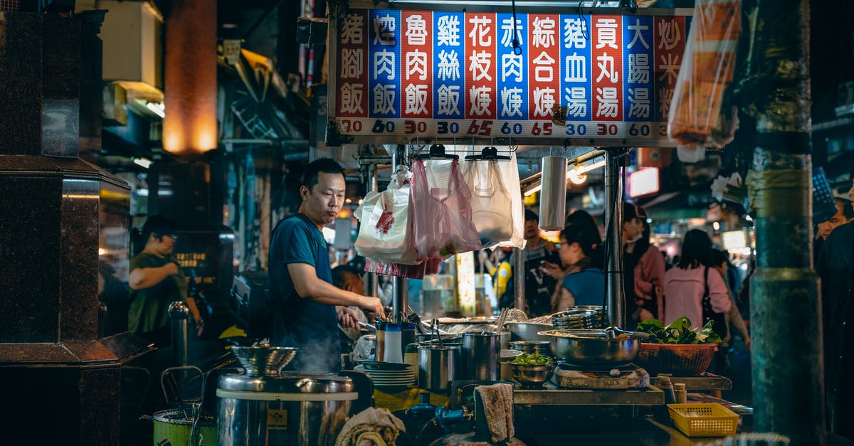 cooking in a plastic bag without removing extra air, at 100c? - Side view of thoughtful male cook looking down while preparing food at table with bowls under colorful signboard with hieroglyphic inscriptions and numbers near customers at night cooking in a plastic bag without removing extra air, at 100c? - Side view of thoughtful male cook looking down while preparing food at table with bowls under colorful signboard with hieroglyphic inscriptions and numbers near customers at night