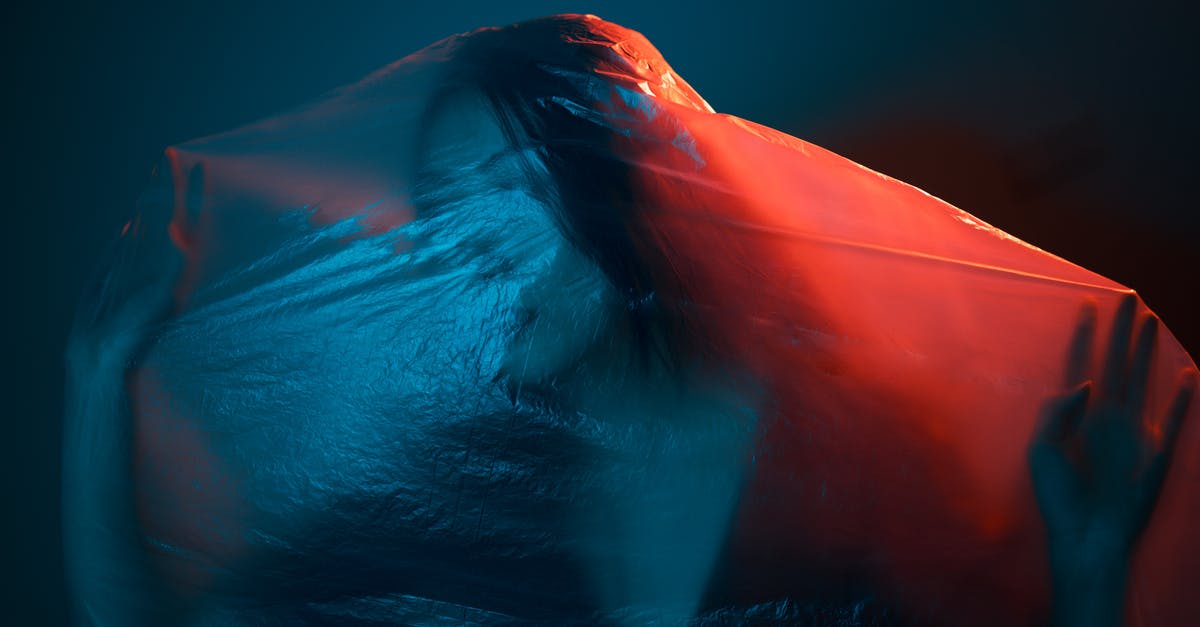 cooking in a plastic bag without removing extra air, at 100c? - Unrecognizable female wrapped with translucent plastic bag in dark room with neon lights cooking in a plastic bag without removing extra air, at 100c? - Unrecognizable female wrapped with translucent plastic bag in dark room with neon lights