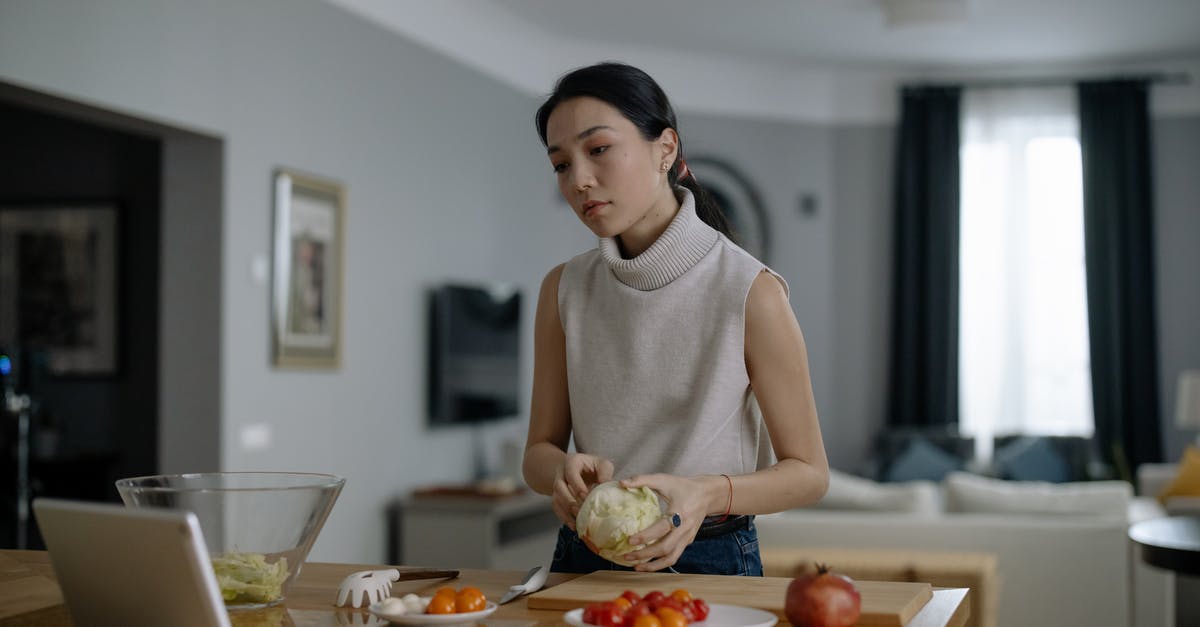 Cooking with Ornamental Cabbage (Kale)? - A Woman Preparing Food While Watching in an Ipad Cooking with Ornamental Cabbage (Kale)? - A Woman Preparing Food While Watching in an Ipad