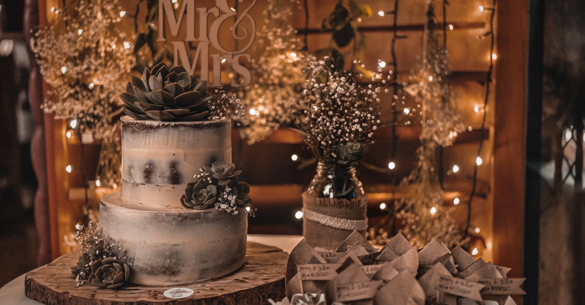 Correct temperature to serve a chocolate gateau (cake) - Wedding cake placed on wooden board near glass bottle with fresh blooming delicate flowers Correct temperature to serve a chocolate gateau (cake) - Wedding cake placed on wooden board near glass bottle with fresh blooming delicate flowers