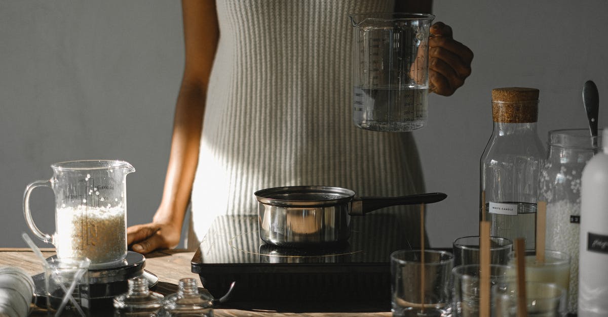 Cranberry beans on a slow cooker (crock pot) - Crop black woman with melted wax at stove making candles