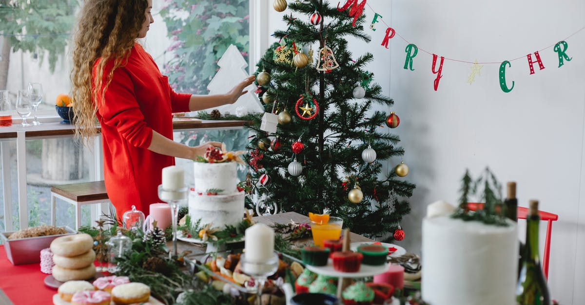 Creme filled doughnuts? Ok at room temp? - Woman decorating Christmas tree in house room with assorted desserts Creme filled doughnuts? Ok at room temp? - Woman decorating Christmas tree in house room with assorted desserts