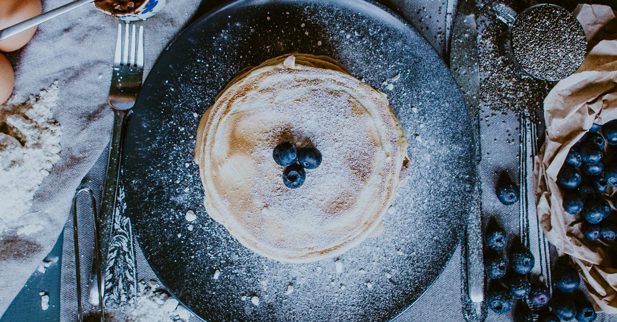 Crepe vs Pancake - From above of plate with yummy homemade golden crepes with fresh blueberries for breakfast Crepe vs Pancake - From above of plate with yummy homemade golden crepes with fresh blueberries for breakfast