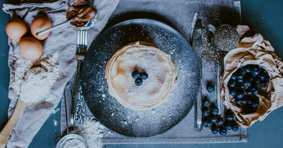 Crepe vs Pancake - Tasty crepes with blueberries and raw ingredients for recipe Crepe vs Pancake - Tasty crepes with blueberries and raw ingredients for recipe