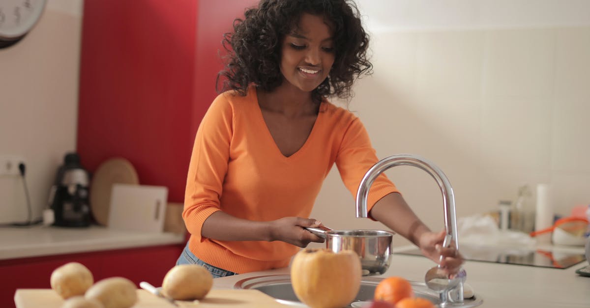 Crock pot left on high for longer than recipe called for - Smiling young ethnic lady in colorful casual clothes standing near sink and pouring water in pot while cooking food in spacious modern kitchen at home Crock pot left on high for longer than recipe called for - Smiling young ethnic lady in colorful casual clothes standing near sink and pouring water in pot while cooking food in spacious modern kitchen at home