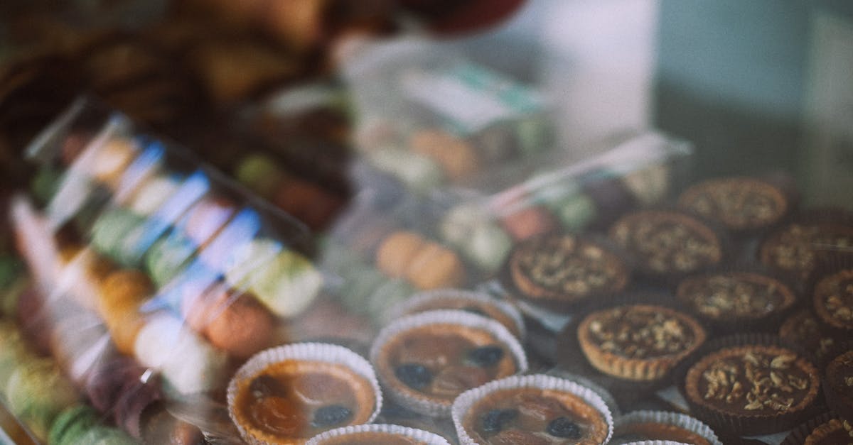 Crunchy vs Chewy dried apples? - Through glass view of different tasty tartlets and macaroons for sale in sweet shop Crunchy vs Chewy dried apples? - Through glass view of different tasty tartlets and macaroons for sale in sweet shop