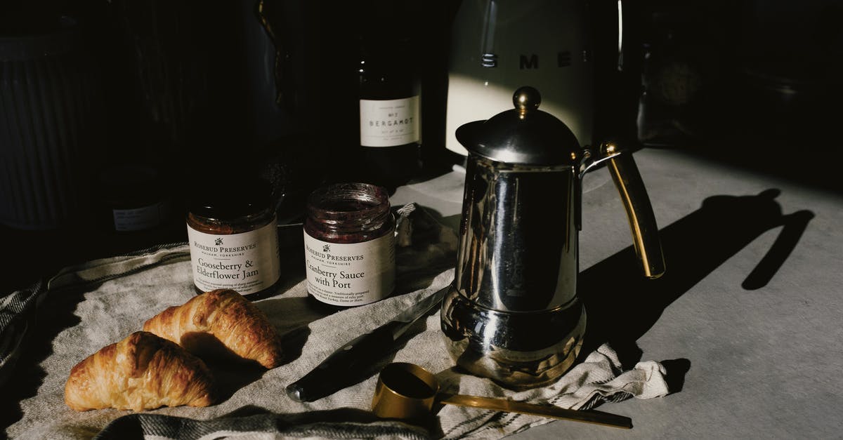 Crusty french bread - Delicious pair of fresh croissants with geyser coffee maker served for breakfast Crusty french bread - Delicious pair of fresh croissants with geyser coffee maker served for breakfast