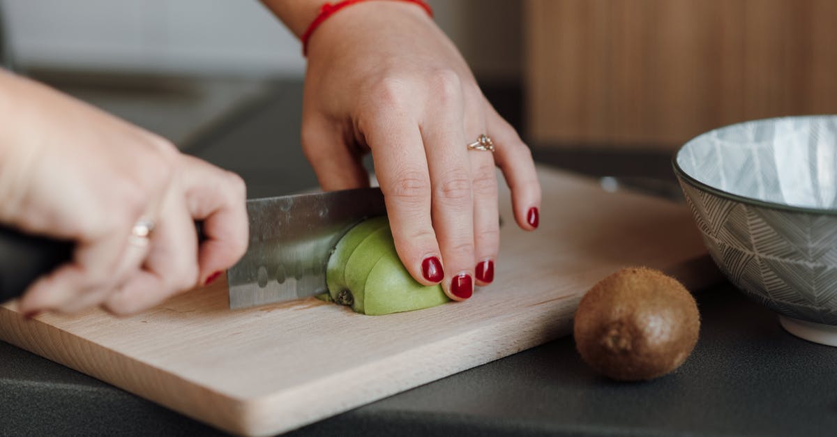 Culinary use for the green parts of lemongrass? - Crop anonymous female cutting ripe green apple on wooden cutting board in kitchen in daytime Culinary use for the green parts of lemongrass? - Crop anonymous female cutting ripe green apple on wooden cutting board in kitchen in daytime