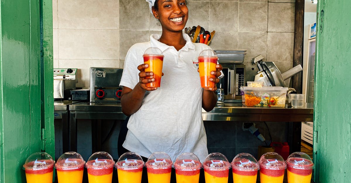 Cup measurements: shake or scrape? - Woman in White Polo Shirt Holding Multicolored Shake in Plastic Cups Cup measurements: shake or scrape? - Woman in White Polo Shirt Holding Multicolored Shake in Plastic Cups
